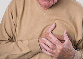 Elderly man grabbing his chest in pain