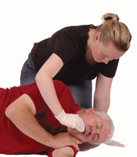 Woman clearing man’s mouth cavity with fingers.