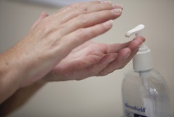 hands dispensing alcohol-based hand rub.