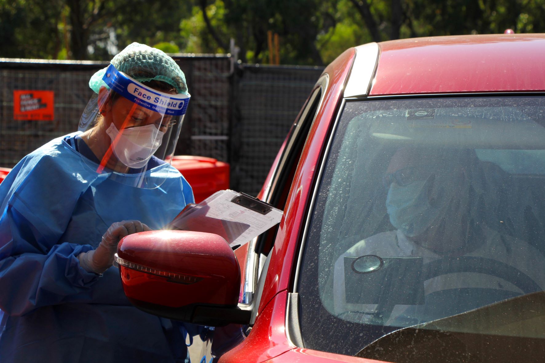 Health officer tests person in COVID drive through testing clinic