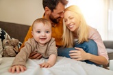 Young parents and their little cute baby boy relaxing on sofa.Happy  mother, father and baby at home.Beautiful young couple with a little boy.